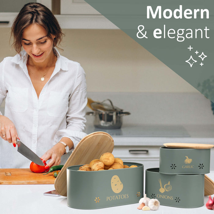 Grey metal vegetable storage bins for storing potatoes, onions, and garlic on the countertop.