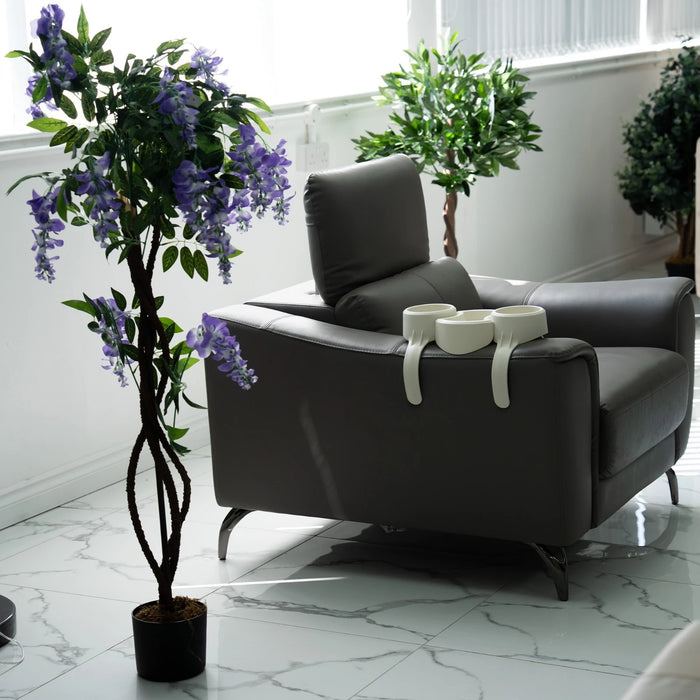 Gray armchair with a plant and decorative items in a modern room.
